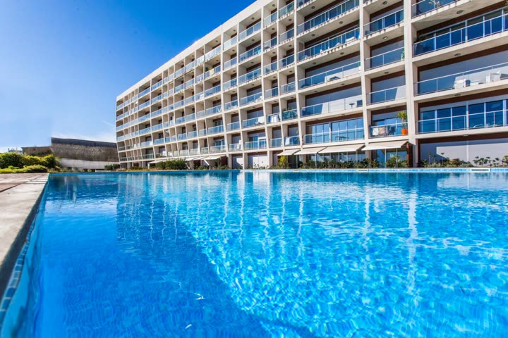 Fachada de um condomínio residencial junto a uma piscina